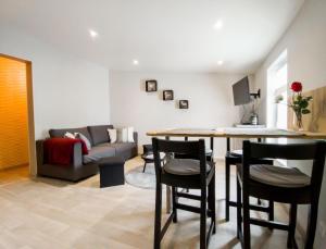 sala de estar con mesa, sillas y sofá en Chaleureux appartement à deux pas du centre-ville de Castillon, de la Dordogne et proche Saint-Emilion, en Castillon-la-Bataille