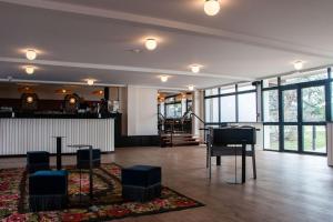 un hall avec un piano et un bar avec des fenêtres dans l'établissement Best Western Porte du Forez, à Andrézieux-Bouthéon