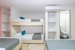 a room with two bunk beds and a toilet at Ayenda Malaki in Medellín
