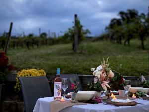 Dixons Creek的住宿－迪瓦恩隱逸山林小屋，一张桌子,上面放着一瓶葡萄酒和鲜花