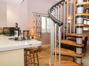 a kitchen with a spiral staircase next to a kitchen counter at Eller Riggs Cottage in Ulverston