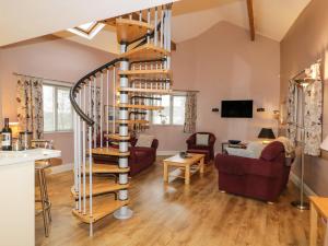eine Wendeltreppe im Wohnzimmer eines Hauses in der Unterkunft Eller Riggs Cottage in Ulverston