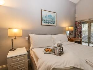 ein Bett mit einem Tablett mit Essen drauf in der Unterkunft Eller Riggs Cottage in Ulverston