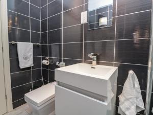 ein Badezimmer mit einem weißen Waschbecken und einer Toilette in der Unterkunft Eller Riggs Cottage in Ulverston + 23 Fotos