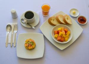 una mesa con un plato de comida y una taza de café en Ayenda Malaki en Medellín