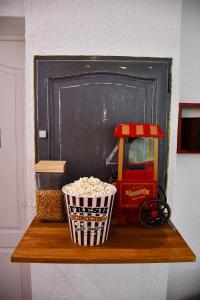 a shelf with a basket of popcorn and a chalkboard at L'Aparté H24,Cosy,Port,Plage,Wifi,Netflix in La Seyne-sur-Mer