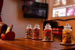 three glass jars filled with candy on a table at L'Aparté H24,Cosy,Port,Plage,Wifi,Netflix in La Seyne-sur-Mer