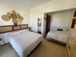福廷的住宿－Recanto Casa de Mila，一间卧室配有两张床和镜子