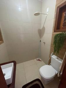 福廷的住宿－Recanto Casa de Mila，浴室配有白色卫生间和盥洗盆。