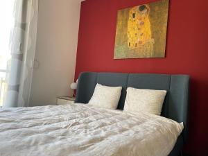 a bedroom with a bed with a painting on the wall at D-S Apartman Stella in Zamárdi