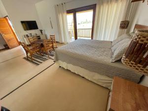 福廷的住宿－Recanto Casa de Mila，卧室配有一张床和一张桌子及椅子