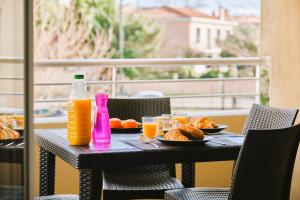 a table with plates of food and bottles of orange juice at Tout confort ! Calme, Climatisation, Piscine, Parking Gratuit, Grande Terrasse, Netflix, Wifi in Carcassonne