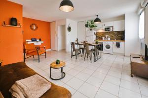 a living room and kitchen with a couch and a table at Tout confort ! Calme, Climatisation, Piscine, Parking Gratuit, Grande Terrasse, Netflix, Wifi in Carcassonne