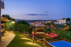a backyard with a pool and chairs and a city at Villa Arade Riverside - Jacuzzi and Heated Pool by SIDE VILLAS in Silves