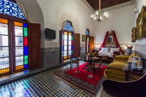 a living room with stained glass windows and a pool at Riad Damia Suite &Spa in Fez