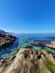 a view of the ocean with rocks in the water at Teatro del Sole Mare Sferracavallo in Palermo