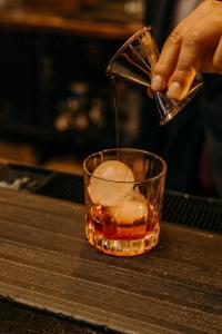 a person is pouring a drink into a glass at Hotel Araiza Mexicali in Mexicali