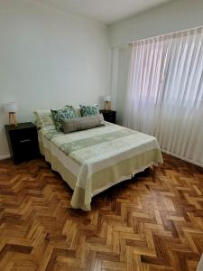 1 dormitorio con 1 cama y suelo de madera en Amplio departamento en Barrio Norte en Buenos Aires