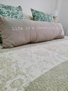 una vida es una almohada de viaje en una cama en Amplio departamento en Barrio Norte en Buenos Aires
