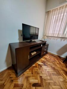 sala de estar con TV de pantalla plana en el suelo de madera en Amplio departamento en Barrio Norte en Buenos Aires