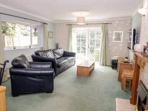 uma sala de estar com um sofá e uma mesa em Treetops em Colwyn Bay
