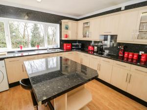 uma cozinha com um balcão preto em Treetops em Colwyn Bay