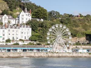 uma roda gigante em frente a um grande edifício branco em Treetops em Colwyn Bay