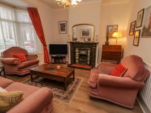 a living room with two couches and a fireplace at Victoria Cottage in Redcar