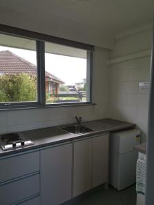 a kitchen with a sink and a window at Kaikoura Motor Inn in Kaikoura