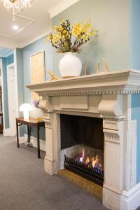 a fireplace with a vase on top of it at Closeburn House in Mount Victoria