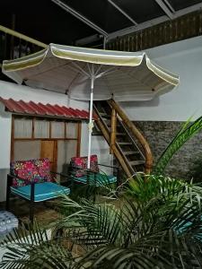 a patio with two chairs and an umbrella at Casa Italia Guest House in Taganga