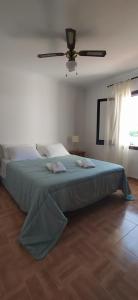 Schlafzimmer mit einem großen Bett und einem Deckenventilator in der Unterkunft Villa Martínez in Cala en Porter