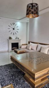 a living room with a couch and a clock on the wall at Nador Khattabi 2-18 in Nador