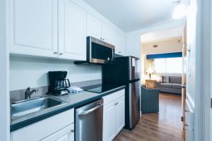 a kitchen with a sink and a microwave at The Atrium Resort, Virginia Beach by Vacatia in Virginia Beach