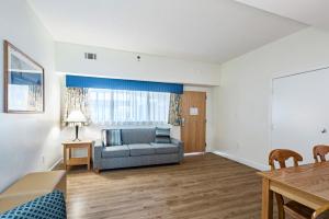a living room with a couch and a table at The Atrium Resort, Virginia Beach by Vacatia in Virginia Beach +14 photos