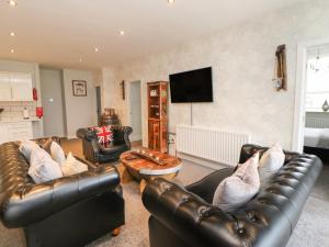 uma sala de estar com mobiliário de couro e uma televisão de ecrã plano em Knights Corner Stanhope Castle em Stanhope