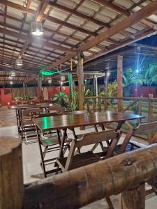 a row of tables and chairs in a restaurant at Pousada Ilha do Meio in Itacimirim