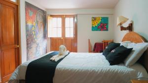 a bedroom with a bed with a stuffed animal on it at Colores Hotel Apu-Linli in Pisac