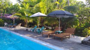 a group of chairs and umbrellas next to a pool at Mahu Lodge in Noloth