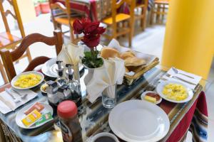 a table with plates of food and flowers on it at Hostel Sol Andina Inn in Puno