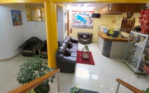 a living room with leather couches and a table at Hostel Sol Andina Inn in Puno