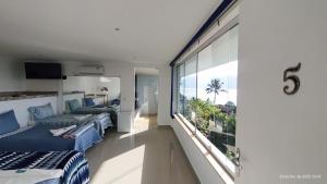 un soggiorno con due letti e una grande finestra di Pousada Refúgio das Estrelas - Vista para o Mar a Ilhabela
