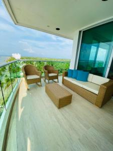 - un balcon avec un canapé et des chaises dans un bâtiment dans l'établissement Hermoso Apartamento frente al mar, 4 habitaciones - Apto 801, à Coveñas
