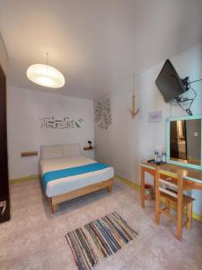 a bedroom with a bed and a tv and a table at Un Sueño Valle de Huajes in Oaxaca City