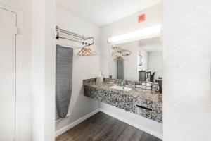 a bathroom with a sink and a mirror at Econo Lodge Inn & Suites Near Bricktown in Oklahoma City +64 photos
