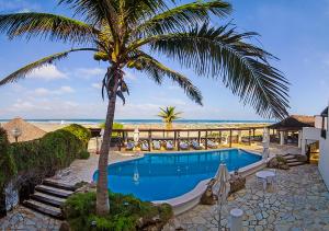 a swimming pool with a palm tree and the beach at Lorencillo Miramar in Tampico