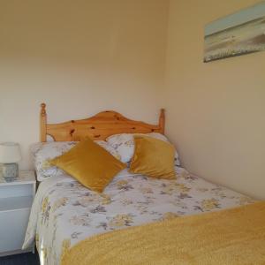 a bedroom with a bed with yellow pillows on it at Ashling House Ardara on Wild Atlantic Way F94T6N7 in Ardara