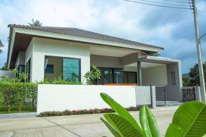 a house with a white wall at Dia House in Ban Phang Ka