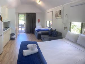 a hotel room with a bed, couch and a television at NRMA Woodgate Beach Holiday Park in Woodgate