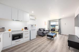 cocina y sala de estar con sofá y mesa en Tekapo Top 1000 Apartment en Lake Tekapo